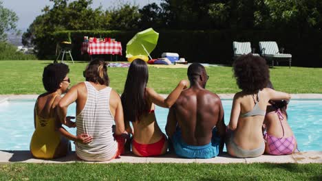 Gruppe-Verschiedener-Freunde,-Die-Bei-Einer-Poolparty-In-Einer-Reihe-Sitzen