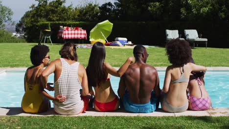 diverse group of friends sitting in a row at a pool party