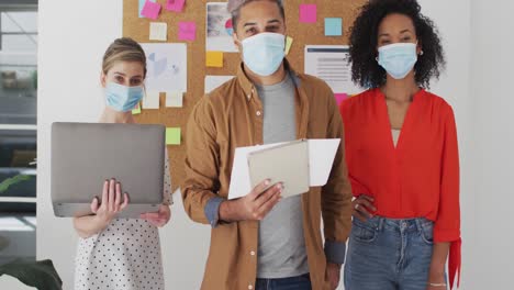 office colleagues wearing face mask standing in office