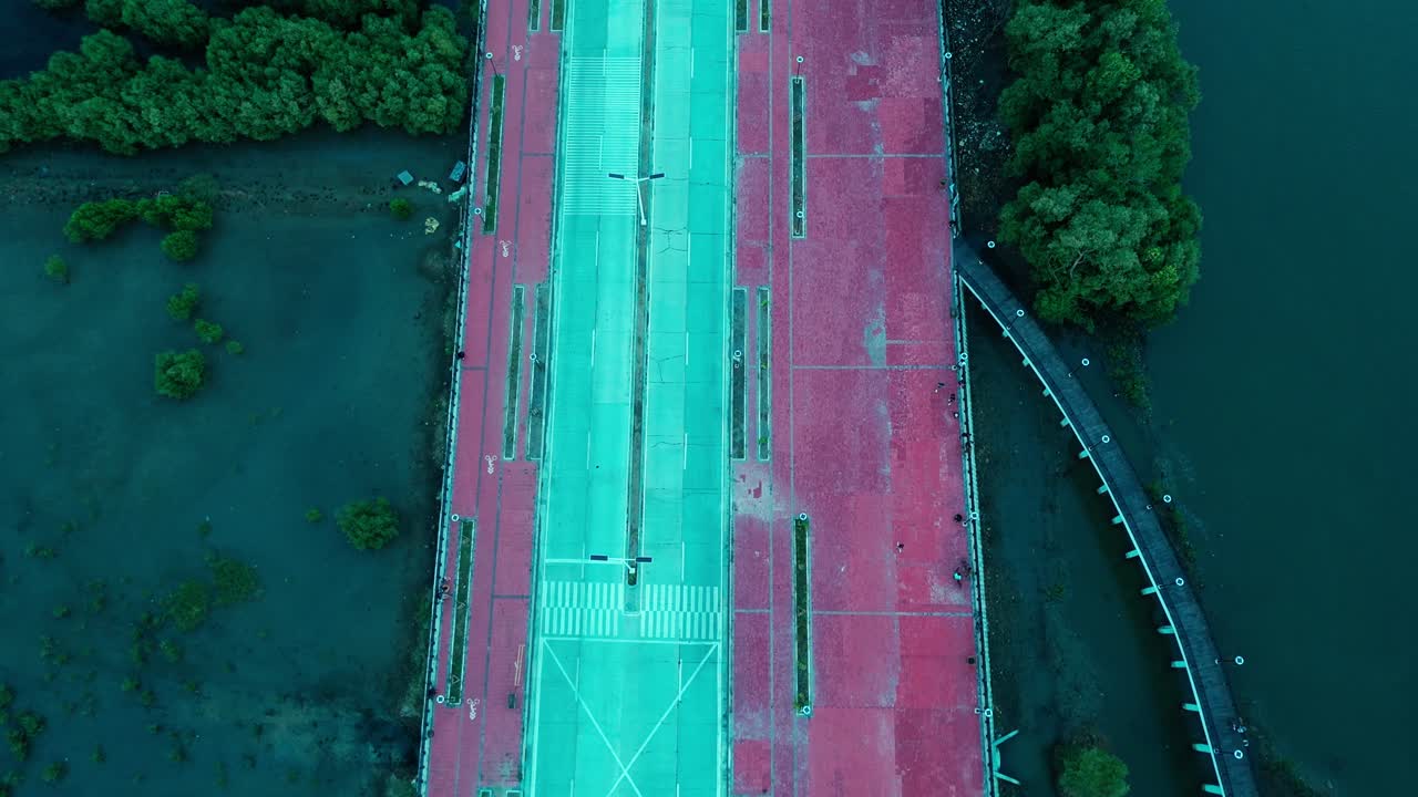 Abstract drone footage of a road intersection and riverside walkway with people in the Philippines. Great for transportation, urban planning, and creative design projects