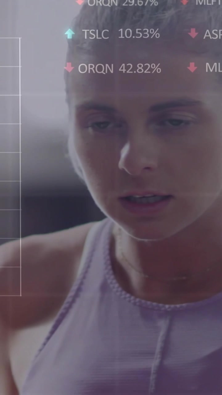 Vertical video: Woman raising arm, HUD graphs appearing over frame, tracking fitness metrics