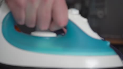 narrow focus ironing blue striped shirt on ironing board, close up