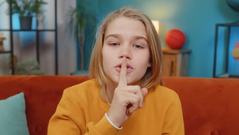 teenager child boy presses finger to lips makes silence hush sign do not tell gossip secret quiet