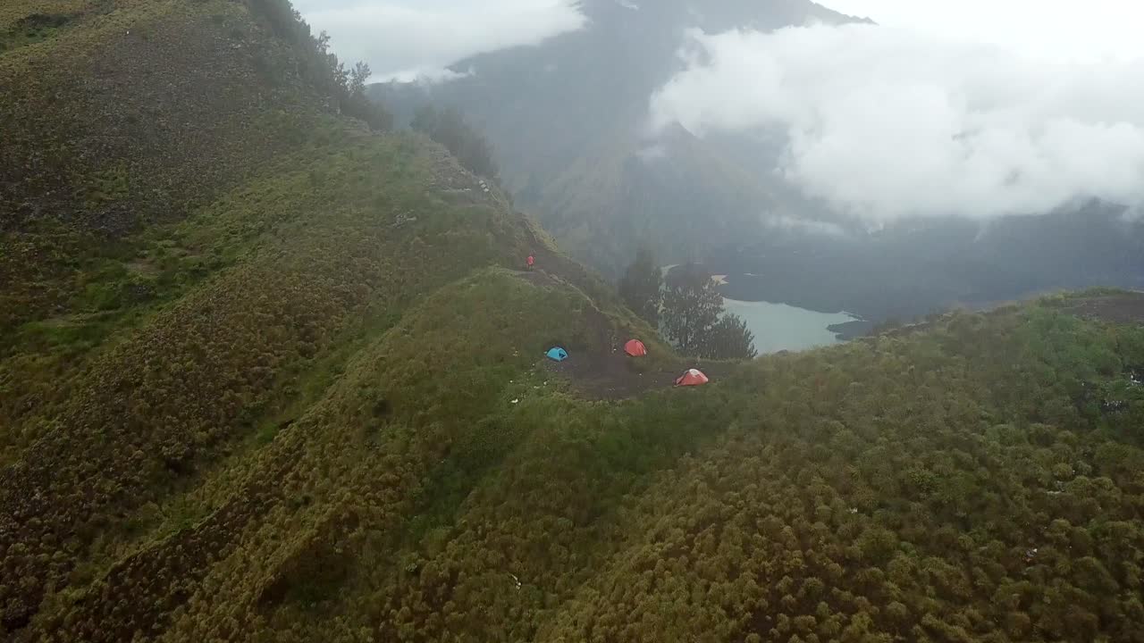toma panorámica aérea de 4k del campamento en el borde del cráter con el lago en el fondo, monte rinjani indonesia