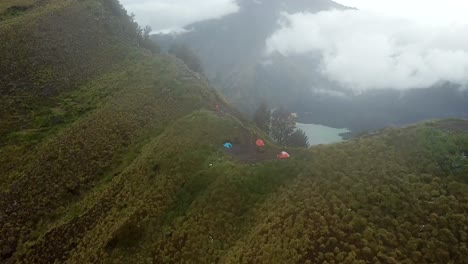 Toma-Panorámica-Aérea-De-4k-Del-Campamento-En-El-Borde-Del-Cráter-Con-El-Lago-En-El-Fondo,-Monte-Rinjani-Indonesia