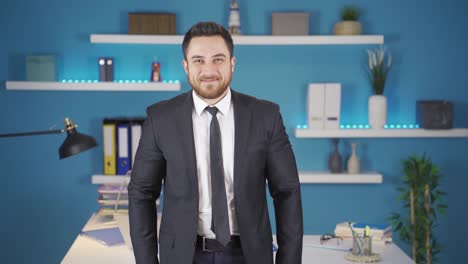 hombre de negocios sonriendo a la cámara haciendo un signo positivo.