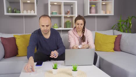 pareja sentada en el sofá en la mesa con billetes. concepto de crisis, falta de dinero, deudas.