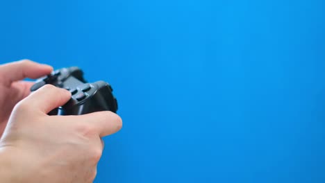 closeup of a man playing on a portable game console on a blue . close-up of a man playing on a portable game console on a blue . joystick for video games isolated on chromakey