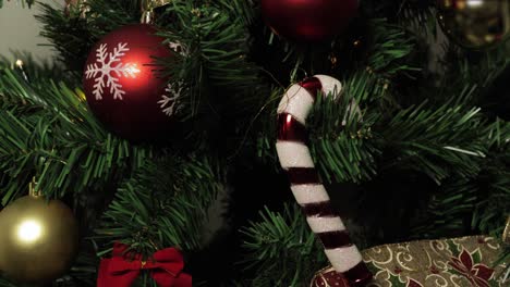 a beautifully decorated christmas tree adorned with red ornaments, snowflake designs, and a candy cane, capturing the festive spirit of the holiday season