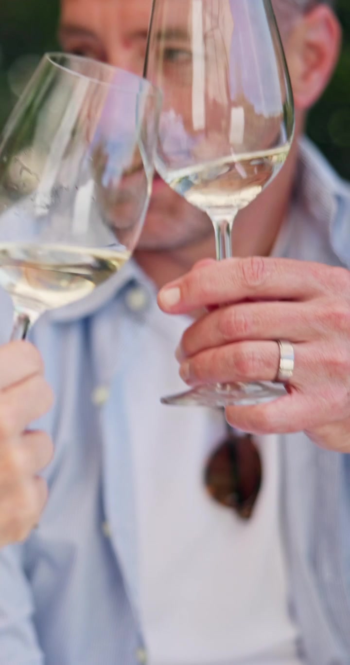 Middle-Aged Man Toasting with White Wine Outdoors