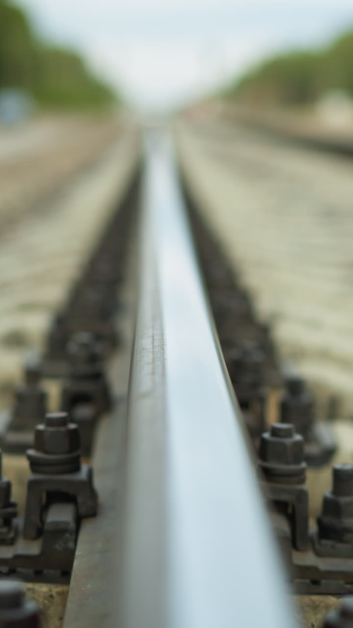 멀리까지 어있는 철도 트랙의 클로즈업 뷰, 비디오는 철도와 그 고정 장치에 초점을 맞추고, 배경은 아름답게 흐릿합니다.