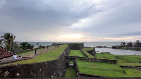 galle dutch fort overlooking the ocean during sunset, capturing the beauty and tranquility of this historic site in sri lanka with lush greenery and coastal waves.