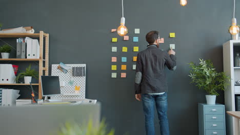 man planning on a wall with post-it notes