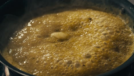 green boiling sauce texture close-up macro. cooking green curry with wooden spoon at home.