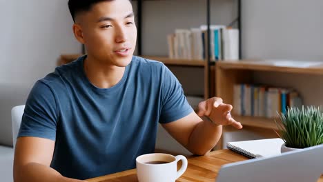 young asian man on video call from home office