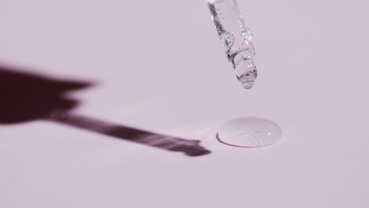 vídeo de la pipeta de maquillaje y las gotas de suero con espacio de copia en fondo rosa