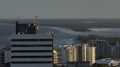 parallax telephoto vista de avión no tripulado de un edificio frente a la playa con vista al océano, costa de sol aérea 4k