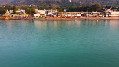 la orilla del río sagrado ganges llena de templos religiosos al atardecer se toma un video aéreo en rishikesh uttrakhand india el 15 de marzo de 2022