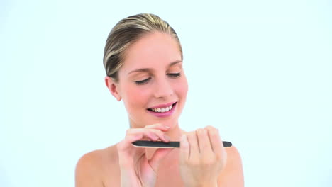 una mujer rubia limpiando sus uñas.
