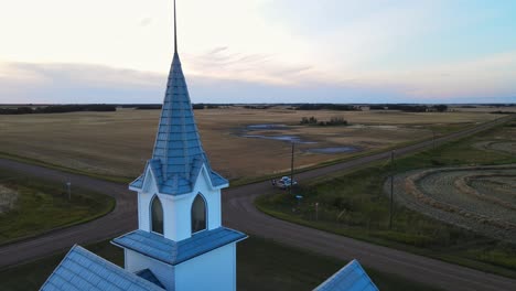 car parked in front of a white and blue country church at sunset in alberta, canada