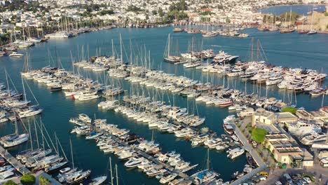 arial drone panning down over the bodrum marina full of sailboats docked in the aegean sea of mugla turkey on a sunny summer afternoon