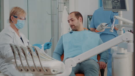 stomatologist showing x ray scan diagnosis to patient