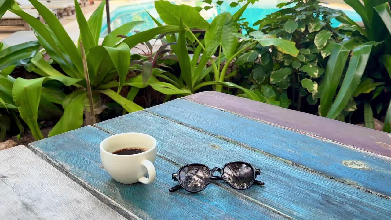 Close Up of Sunglasses and Coffee Cup on Wooden Bench in Tropical Resort Morning Paje Zanzibar Tanzania