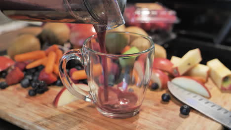 fresh juice being poured into glass from juicer