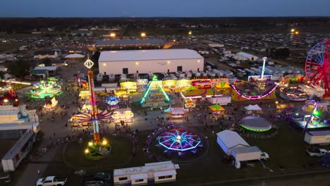 glowing carnival with ferris wheel and other attractions, aerial view