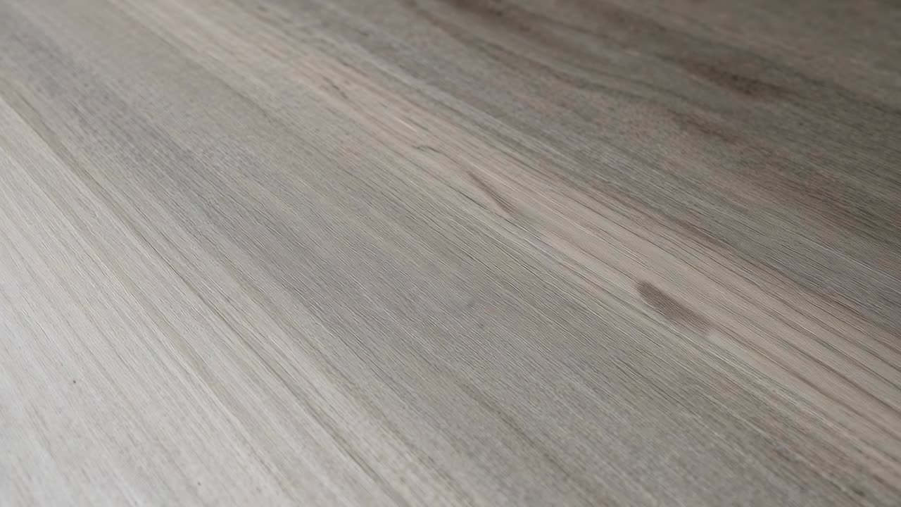 Inclinazione della camera con scorrimento sulla superficie in legno chiaro del tavolo, rivelando nodi e trama