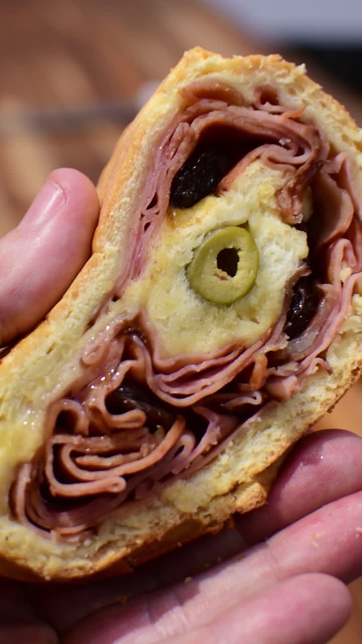 Primo piano verticale che mostra le texture e gli ingredienti di un taglio di pan de jamon.