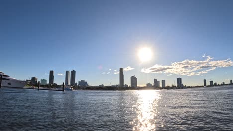 sun setting over city skyline and water