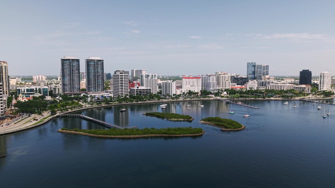 Aerea: ripresa con drone in allontanamento della marina, del porto e del paesaggio urbano di West Palm Beach con yacht bianchi di giorno in Florida, USA.