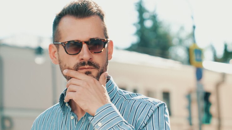 Uomo con occhiali da sole, che guarda altrove, all'aperto