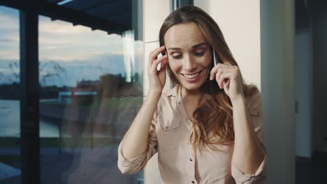 mujer feliz hablando móvil en la casa. retrato de mujer sonriente hablando por teléfono.