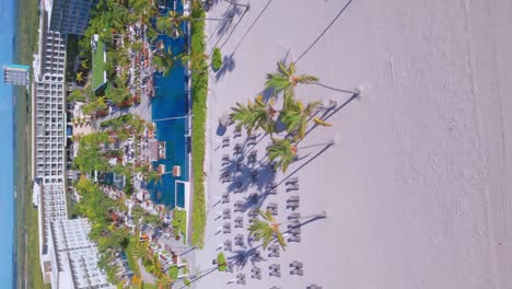 tiro vertical de hotel y resort frente a la playa, paraíso tropical y playa de arena blanca en verano en punta cana, república dominicana