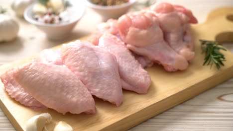 fresh raw chicken wings on wooden board with ingredients