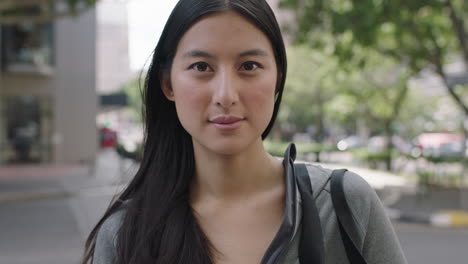 portrait of lovely young beautiful asian woman looking pensive contemplative on urban city sidewalk