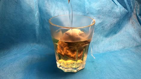 a tea bag is brewed in a glass.