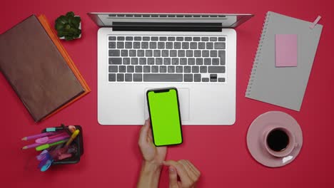 mujer usando el teléfono mientras trabaja en la computadora portátil