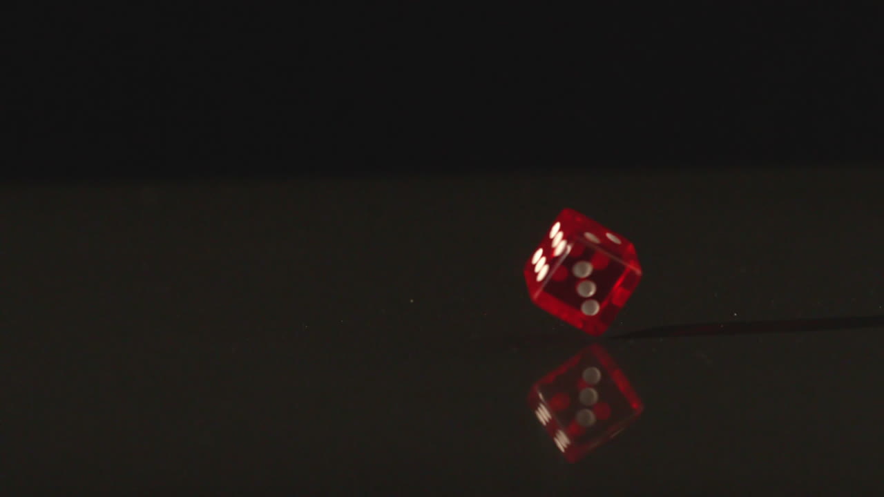 Red dice revolving on black background