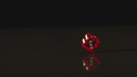 red dice revolving on black background