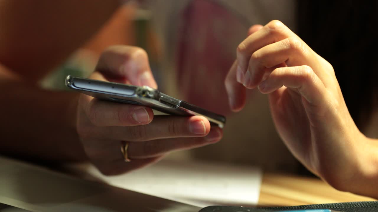primer plano de manos navegando por internet con un dispositivo de teléfono móvil en 4k. mujer desplazándose y tocando la pantalla.