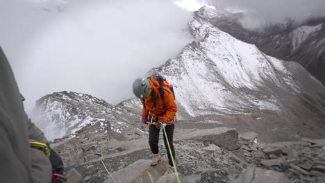 traditional climbing - female climber abseiling, rappelling down on steep mountain cliff