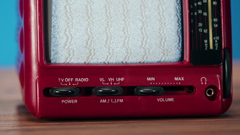 close-up of a retro portable tv with static on the screen