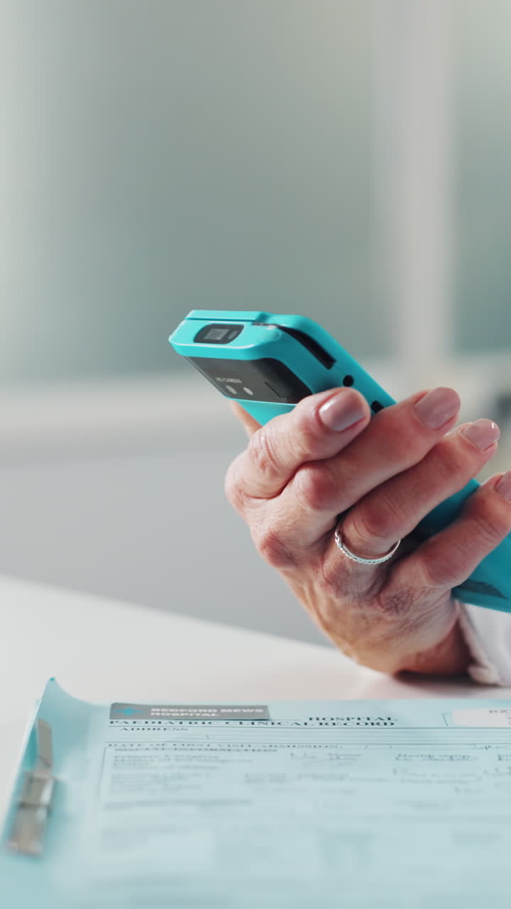 Close-up of Hand Holding Smartphone Near Medical Record