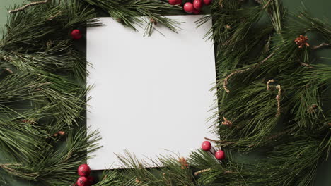 video of christmas decorations and white card with copy space on green background