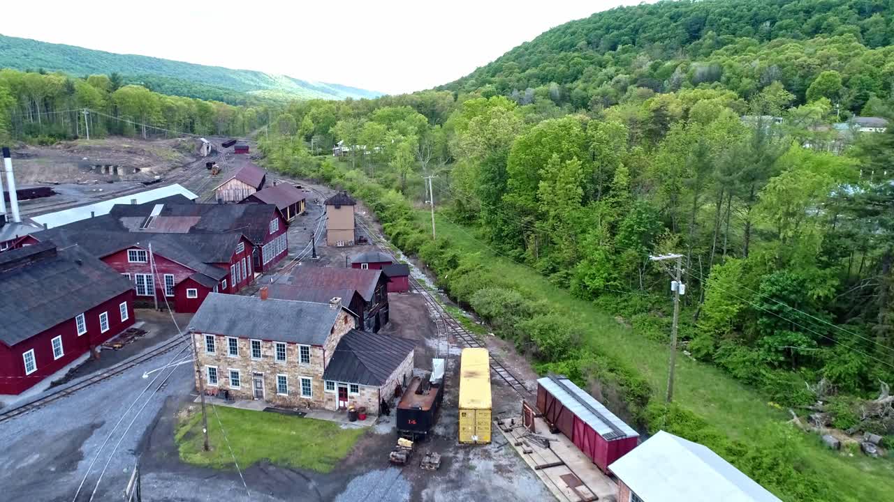 una vista aérea de una casa redonda de ferrocarril de carbón de vía estrecha abandonada y un edificio de soporte giratorio que comienza a restaurarse