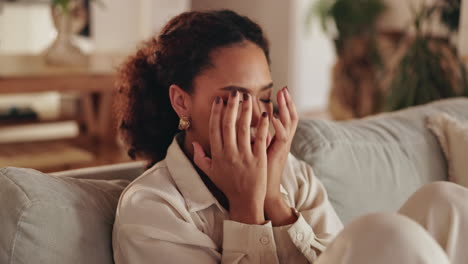 woman sitting on a couch covering her face