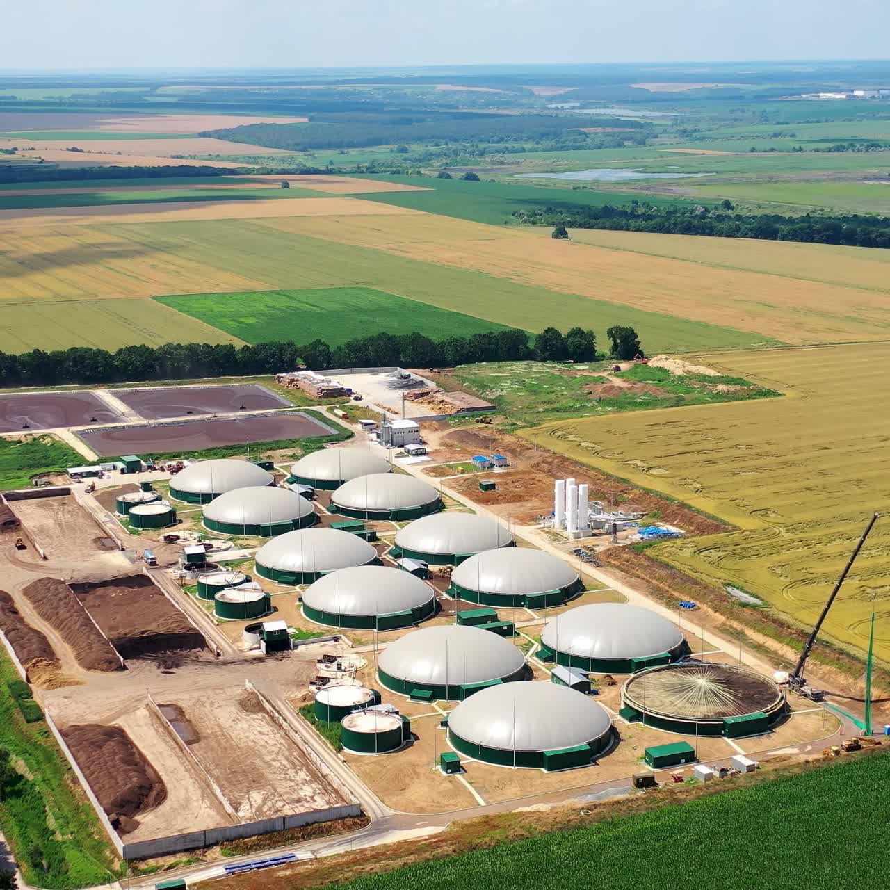 Biogas plant. Farm for renewable energy from biomass. Modern agriculture on field. Aerial view